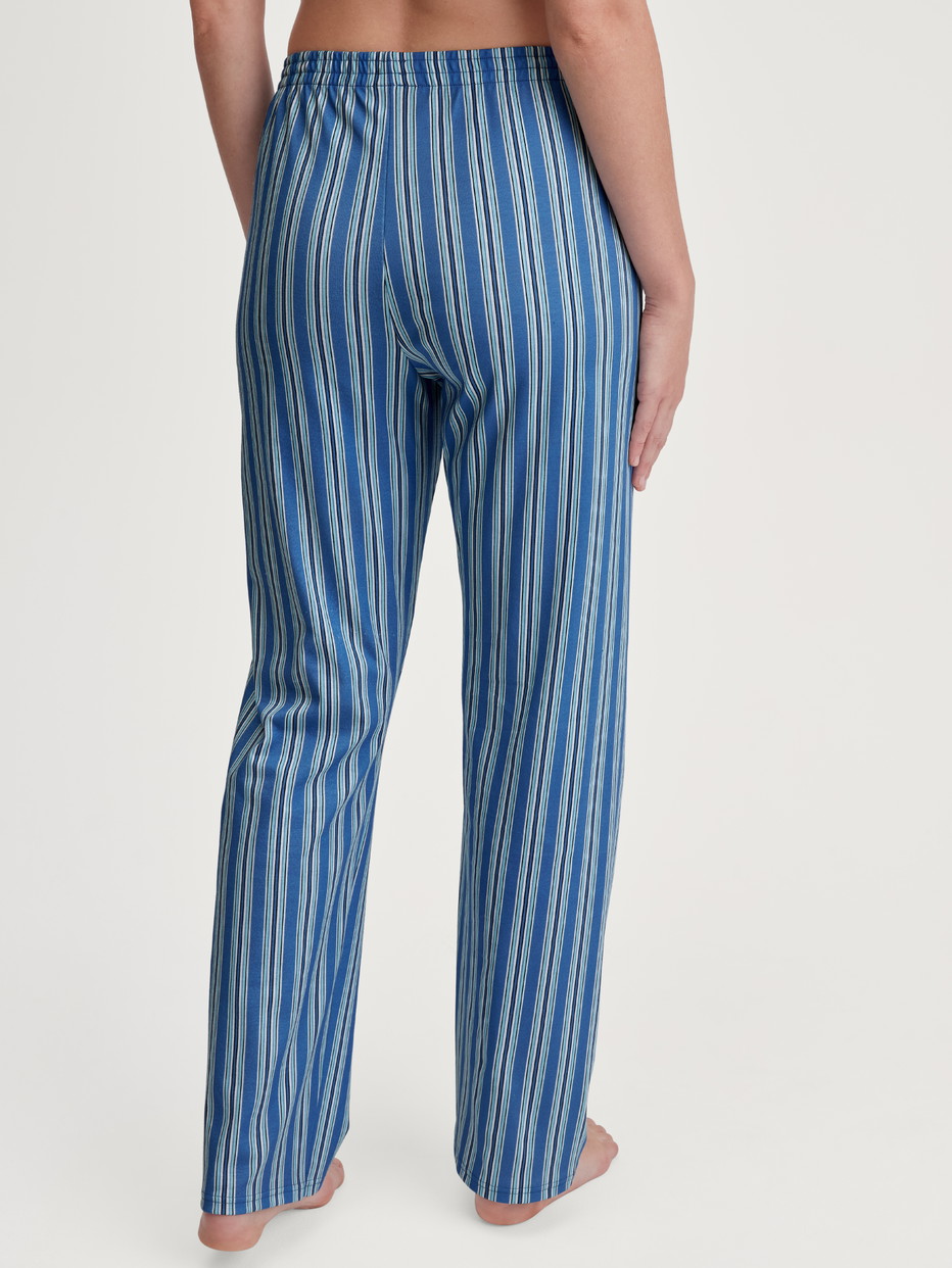 Damen-Model trägt Pyjamahose aus 100% Baumwolle in Blau, Gestreift aus Serie Favourites Journey von CALIDA, Rückansicht