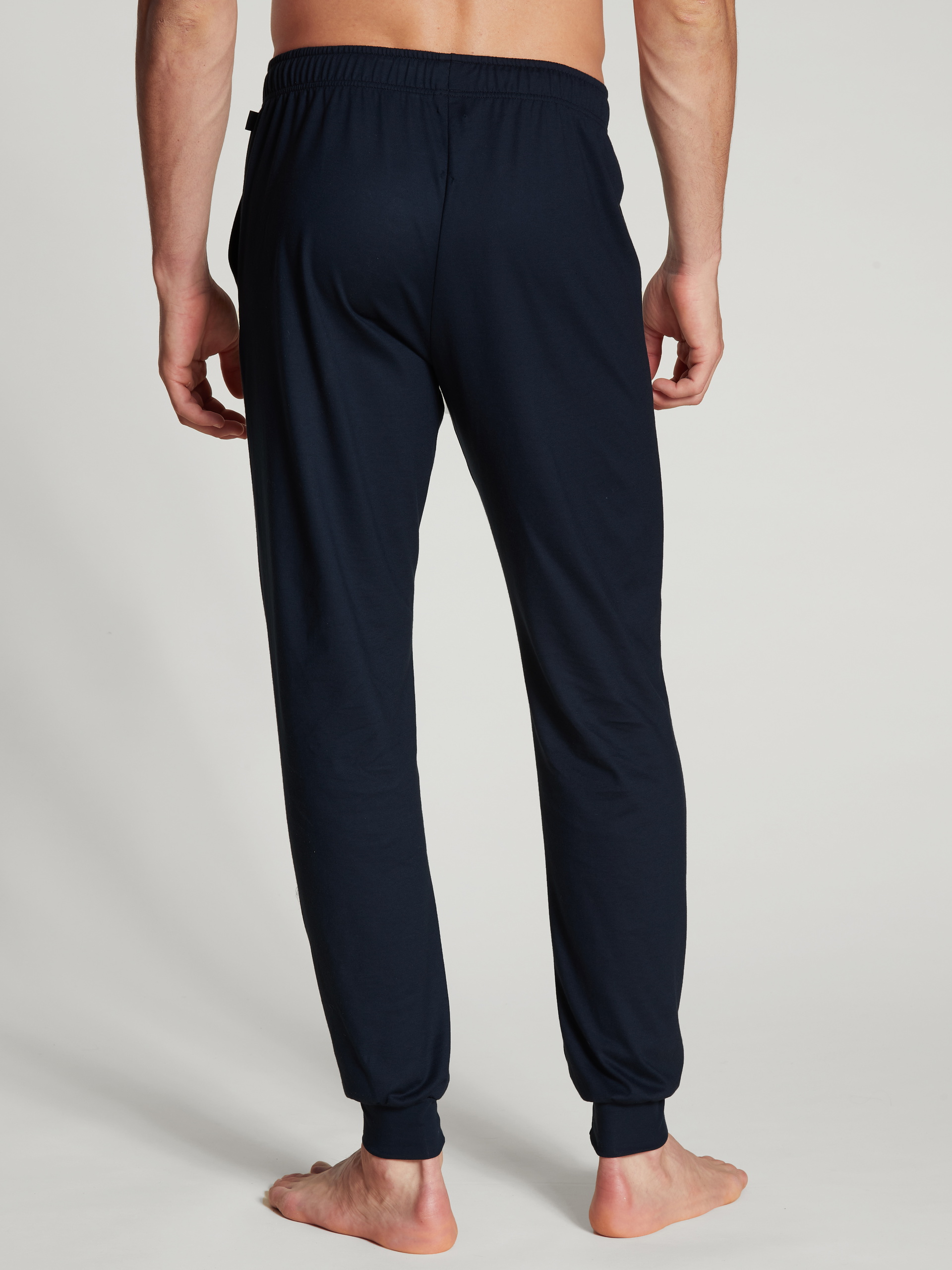 Herren-Model trägt Pants mit Bündchen aus 100% Baumwolle in Blau, Einfarbig aus Serie Remix Basic Sleep von CALIDA, Rückansicht
