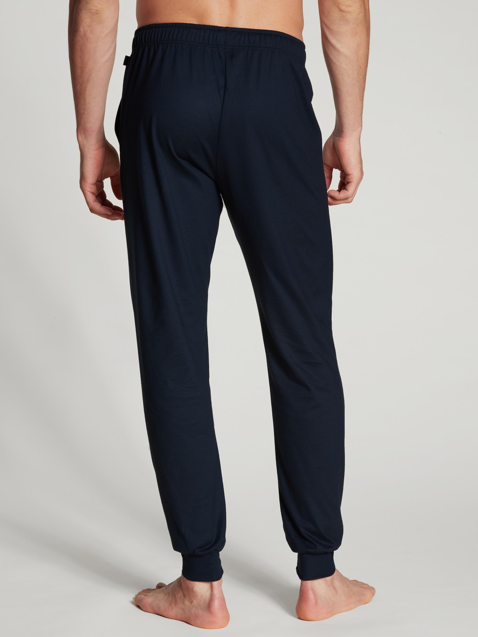 Herren-Model trägt Pants mit Bündchen aus 100% Baumwolle in Blau, Einfarbig aus Serie Remix Basic Sleep von CALIDA, Rückansicht