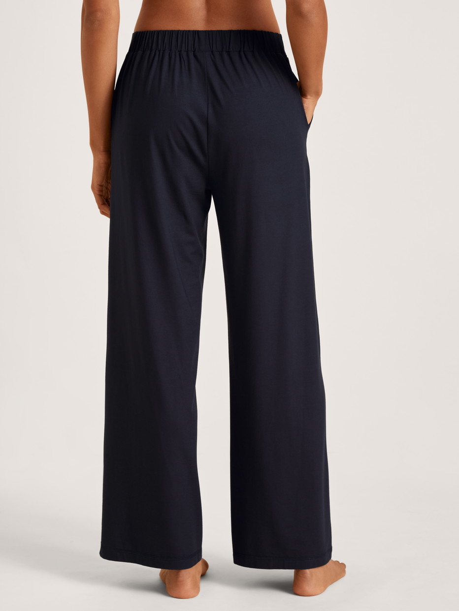Damen-Model trägt Pyjamahose aus Modal in Blau, Einfarbig aus Serie DSW Balancing von CALIDA, Rückansicht