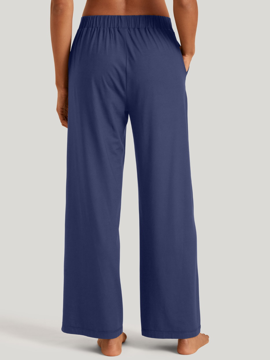 La modella / Il modello Donna indossa Pantaloni pigiama in Modal di colore Blu, Tinta unita, della serie DSW Balancing di CALIDA, Vista posteriore