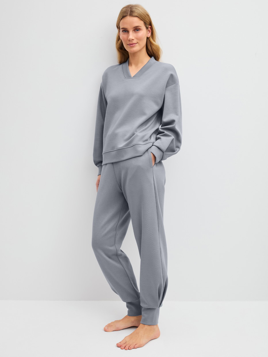 Damen-Model trägt Loungehose mit Bündchen aus Baumwolle in Grau, Einfarbig aus Serie Natural Embrace von CALIDA, Outfit