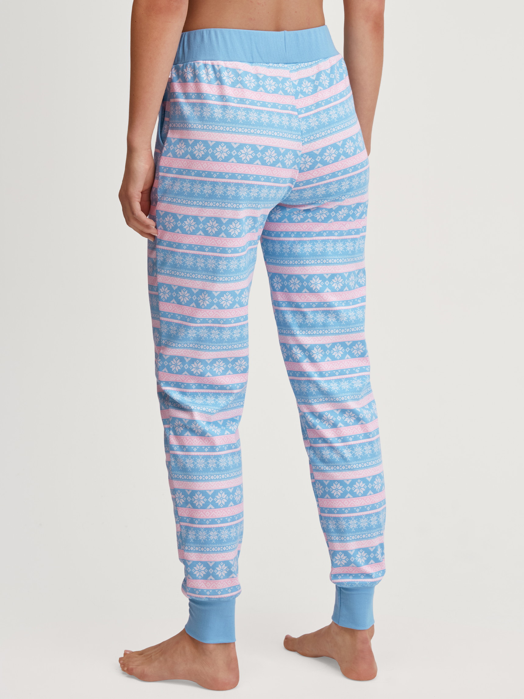 Damen-Model trägt Pyjamahose mit Bündchen aus 100% Baumwolle in Blau, Gemustert aus Serie Ski Resort von CALIDA, Rückansicht