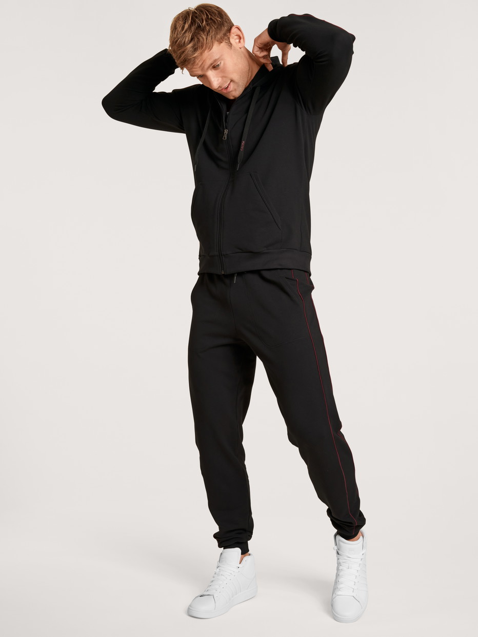 Le mannequin Homme porte le/la Pantalon de jogging en Coton de couleur Noir, Unicolore, de la série Remix Basic Lounge de CALIDA, Vue de face, Tenue