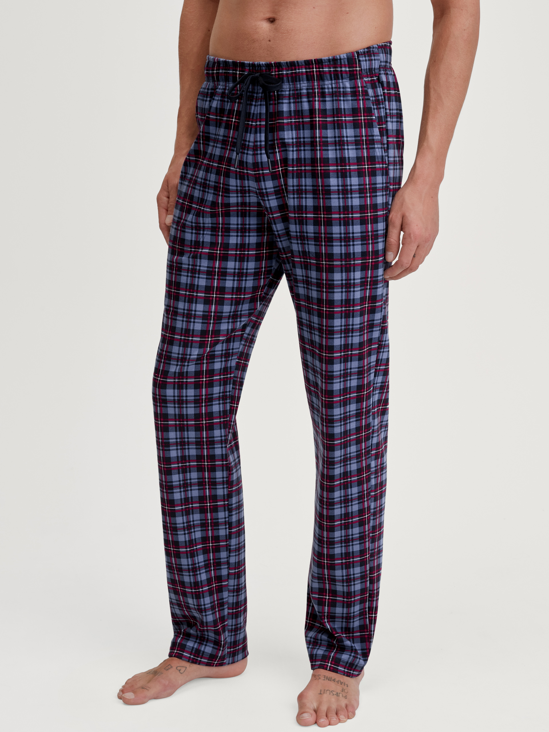 Herren-Model trägt Pyjamahose mit Seitentaschen aus 100% Baumwolle in Blau, Gemustert aus Serie Family & Friends von CALIDA, Vorderansicht