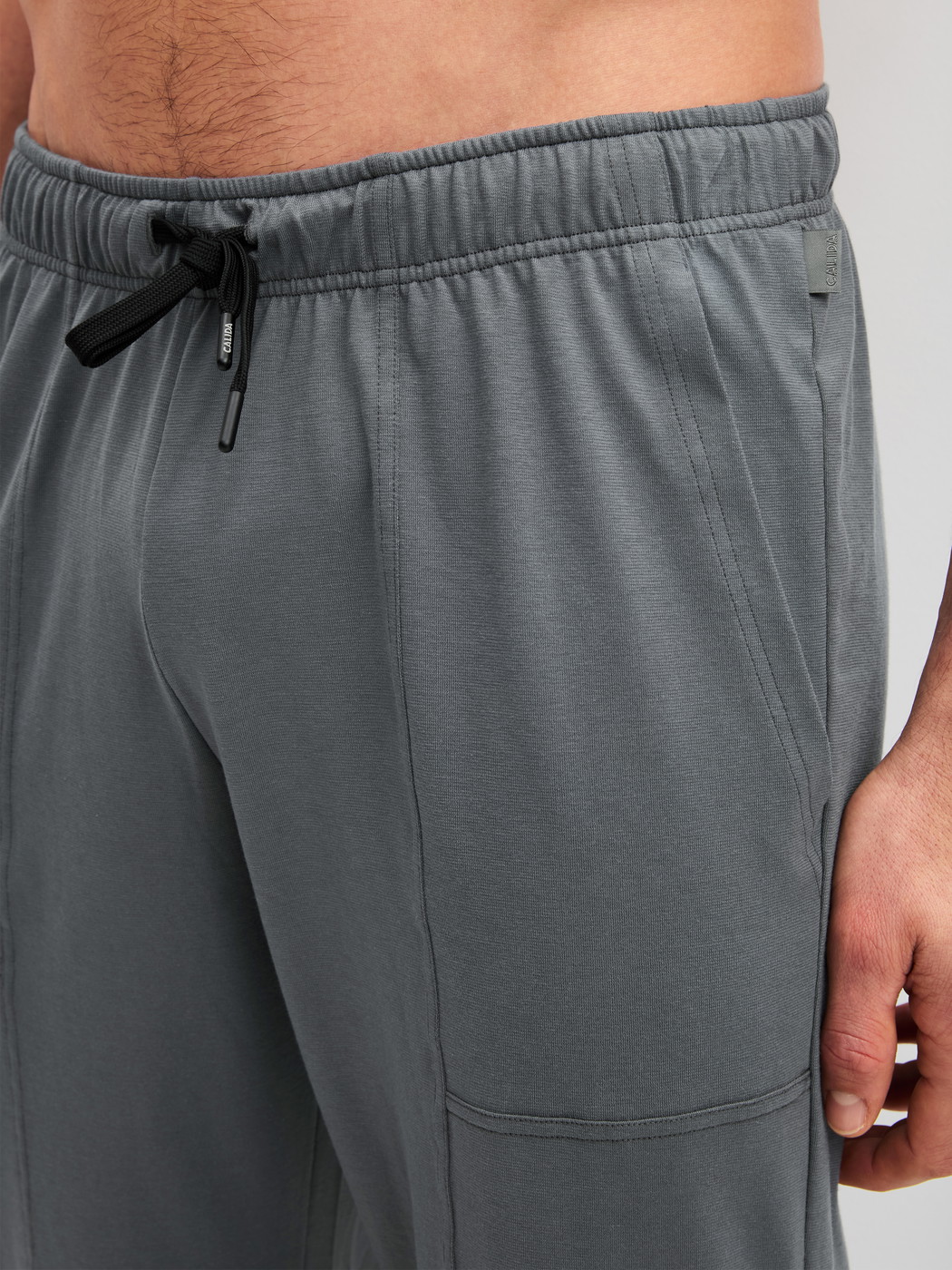 Herren-Model trägt Pyjamahose mit Seitentaschen aus 100% Baumwolle in Grau, Einfarbig aus Serie RMX Sleep Leisure von CALIDA, Detail