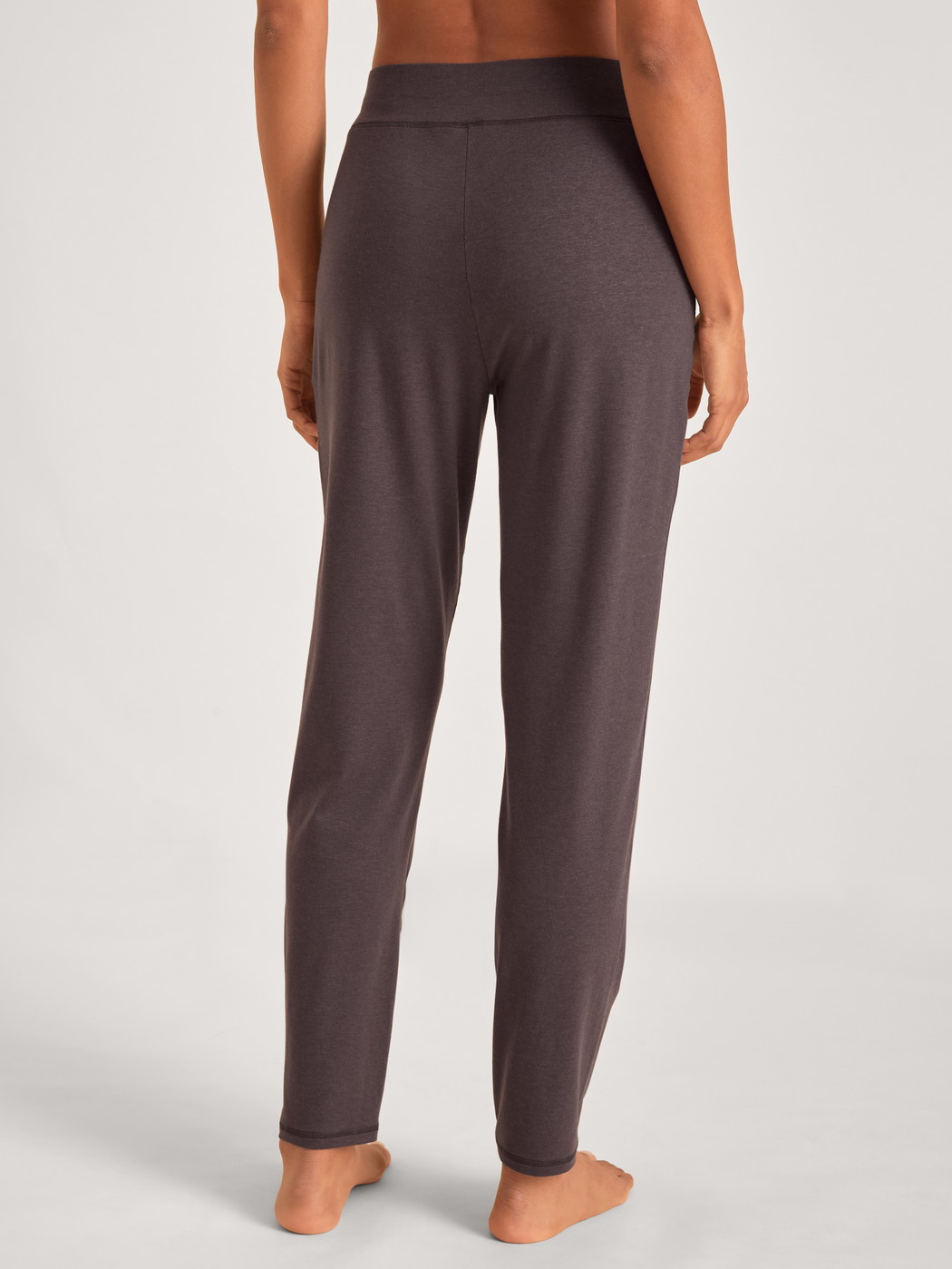 Damen-Model trägt Pyjamahose mit Seitentaschen aus Lyocell in Violett, Einfarbig aus Serie DSW Warming von CALIDA, Rückansicht