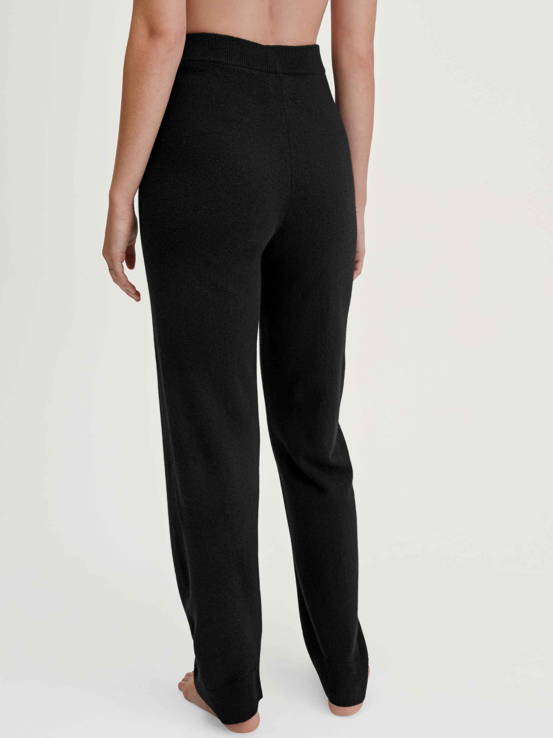 Women model is wearing Merino wool knitted trousers made of Wool in Black, Unicoloured from the The Cosy Collection series by CALIDA, Back view