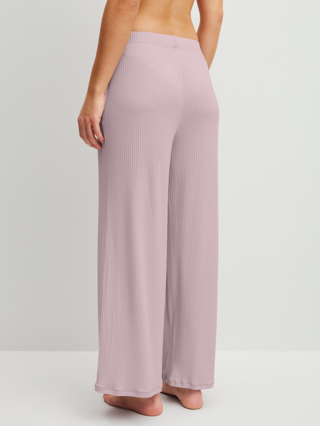 Damen-Model trägt Loungehose aus TENCEL™ Modal aus Modal in Violett, Einfarbig aus Serie Feminine Lounge von CALIDA, Rückansicht