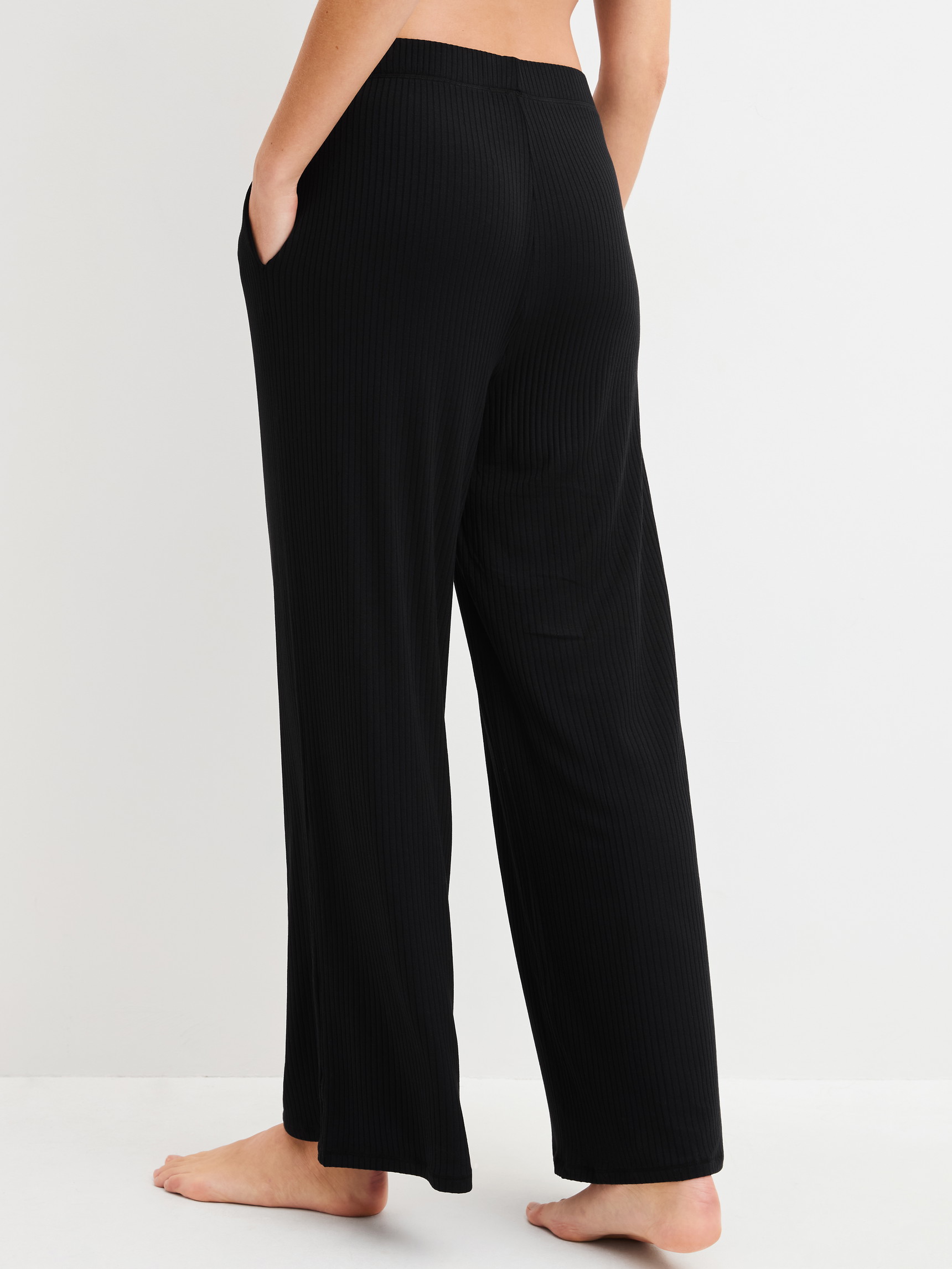 Damen-Model trägt Loungehose aus TENCEL™ Modal aus Modal in Schwarz, Einfarbig aus Serie Feminine Lounge von CALIDA, Rückansicht