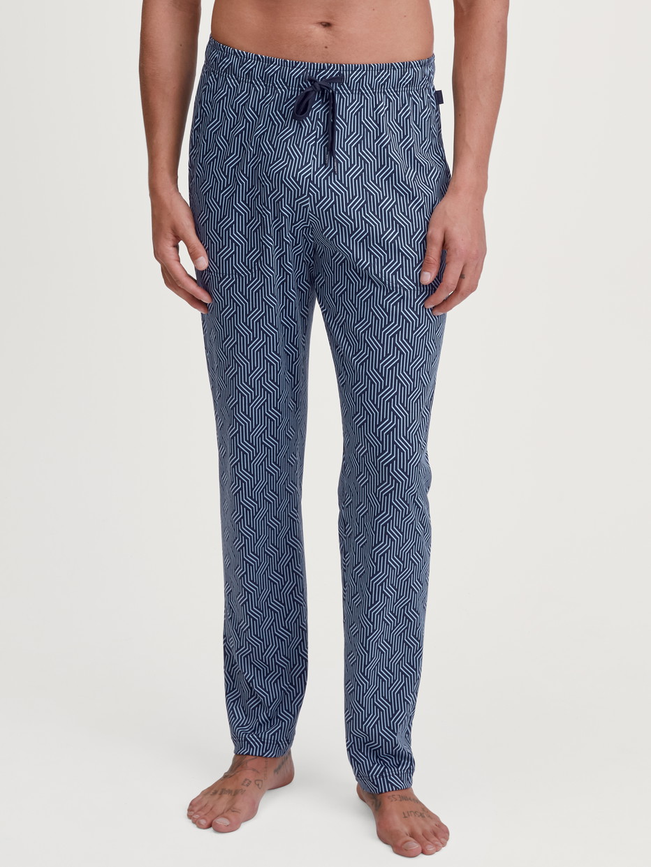 Herren-Model trägt Pyjamahose mit Seitentaschen aus Baumwolle in Blau, Gemustert aus Serie RMX Sleep Free von CALIDA, Vorderansicht