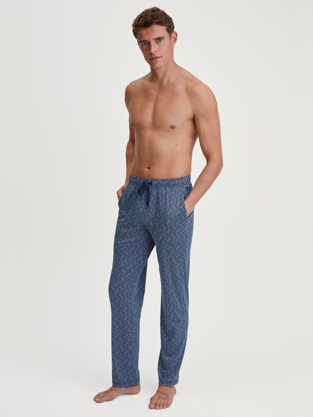 La modella / Il modello Uomo indossa Pantaloni da notte con tasche in Cotone di colore Blu, Modello, della serie RMX Sleep Free di CALIDA, Abbigliamento