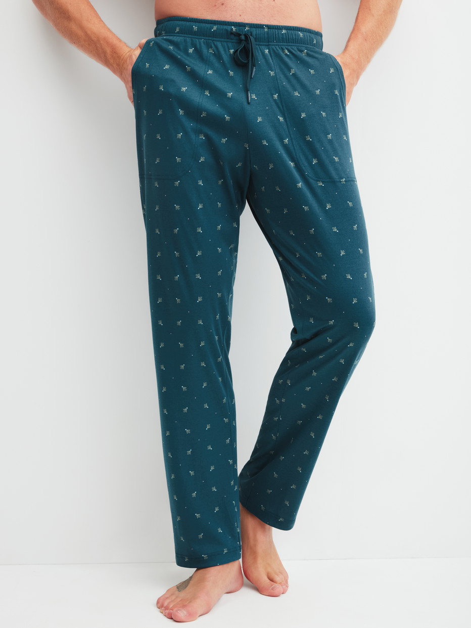Herren-Model trägt Pyjamahose mit Seitentaschen aus Baumwolle in Türkis, Gemustert aus Serie RMX Sleep Free von CALIDA, Vorderansicht