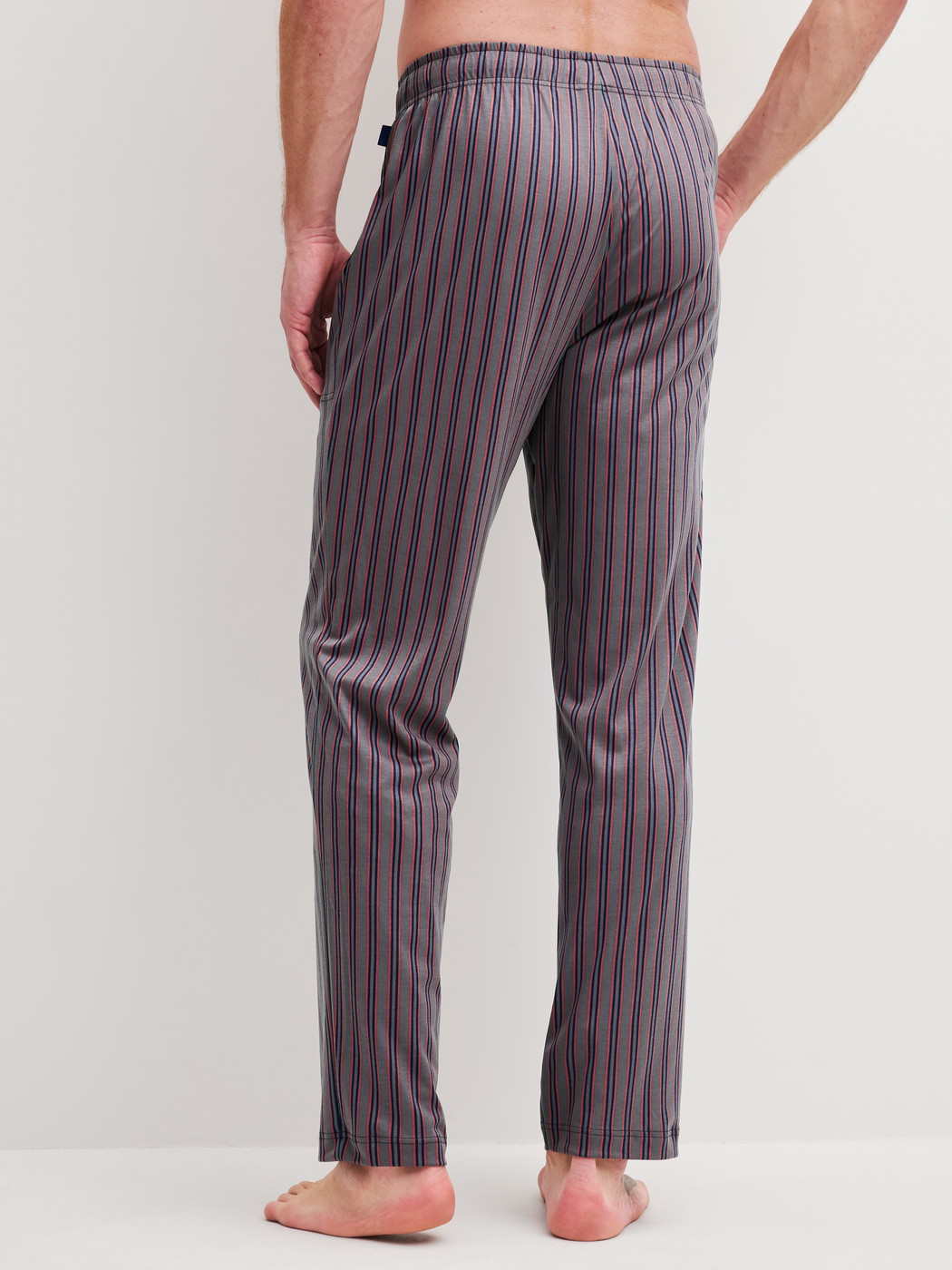 Men model is wearing Pyjama Bottoms with Side Pockets made of Cotton in Brown, Striped from the RMX Sleep Superlight series by CALIDA, Back view