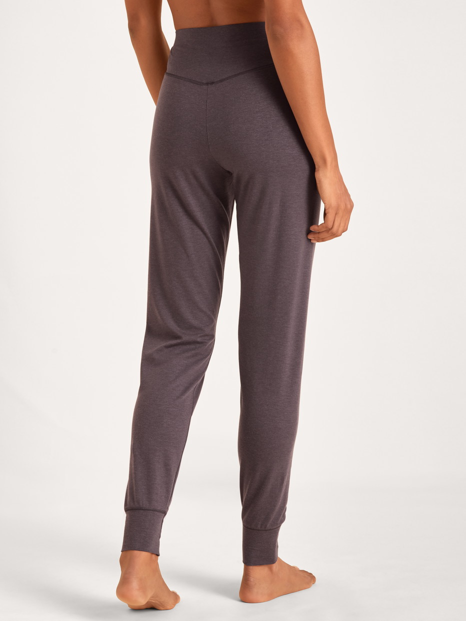 La modella / Il modello Donna indossa Pantaloni pigiama con polsini in Lyocell di colore Viola, Tinta unita, della serie DSW Warming di CALIDA, Vista posteriore