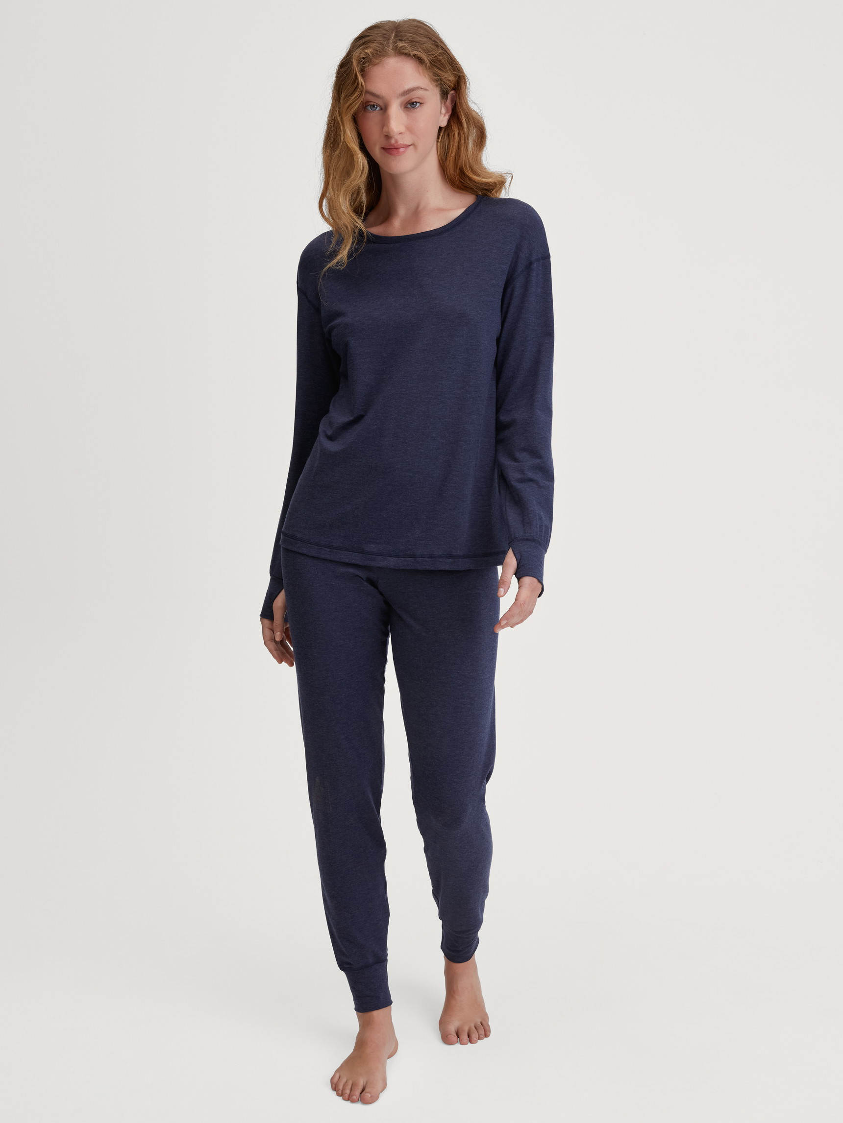 La modella / Il modello Donna indossa Pantaloni pigiama con polsini in Lyocell di colore Blu, Tinta unita, della serie DSW Warming di CALIDA, Abbigliamento