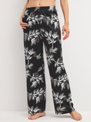 Damen-Model trägt Pyjamahose mit Seitentaschen aus Modal in Schwarz, Floral aus Serie Glimmer M&M von CALIDA, Vorderansicht