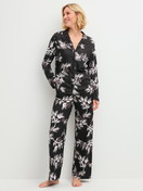 Damen-Model trägt Pyjamahose mit Seitentaschen aus Modal in Schwarz, Floral aus Serie Glimmer M&M von CALIDA, Outfit