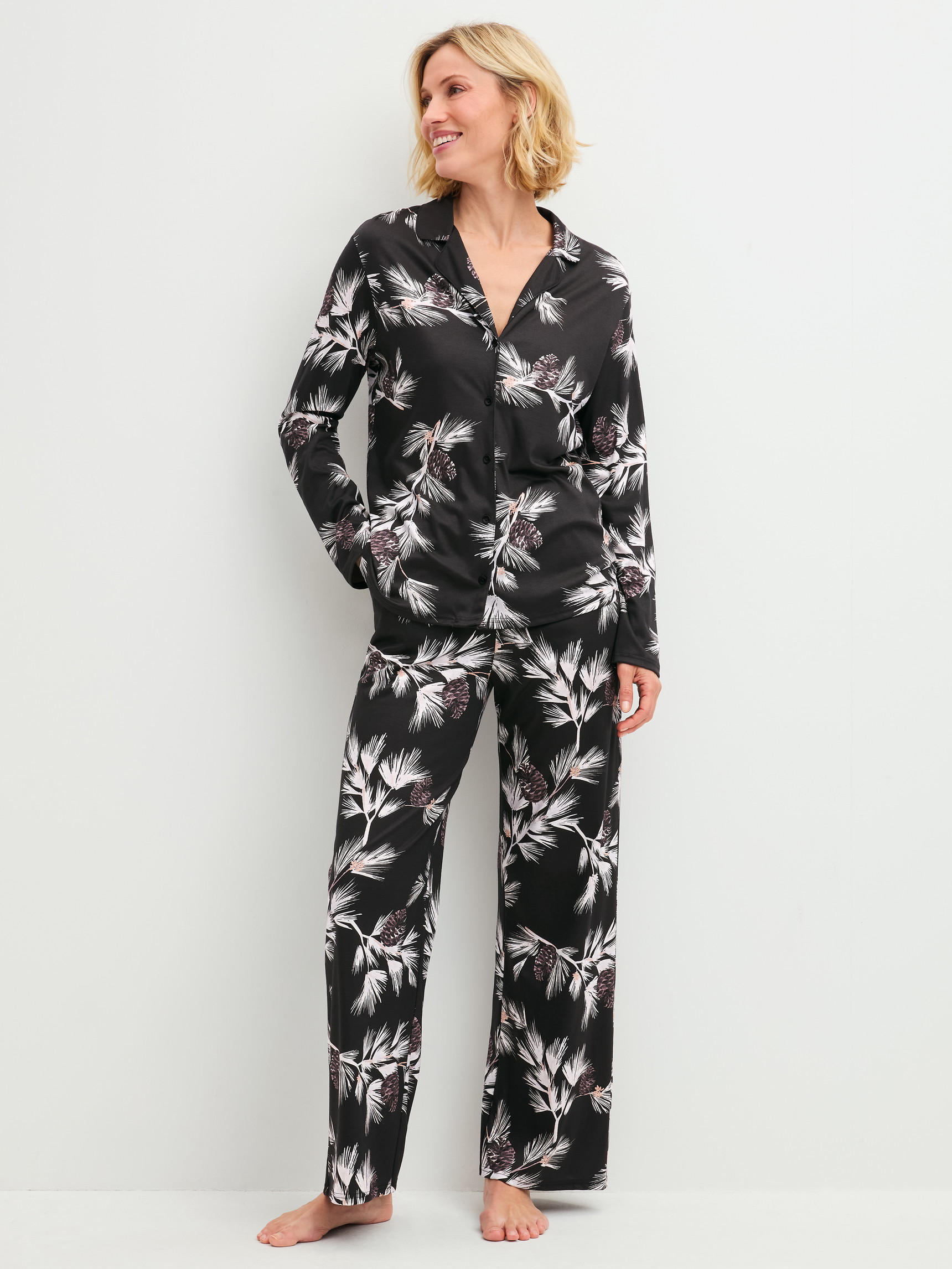 Damen-Model trägt Pyjamahose mit Seitentaschen aus Modal in Schwarz, Floral aus Serie Glimmer M&M von CALIDA, Outfit