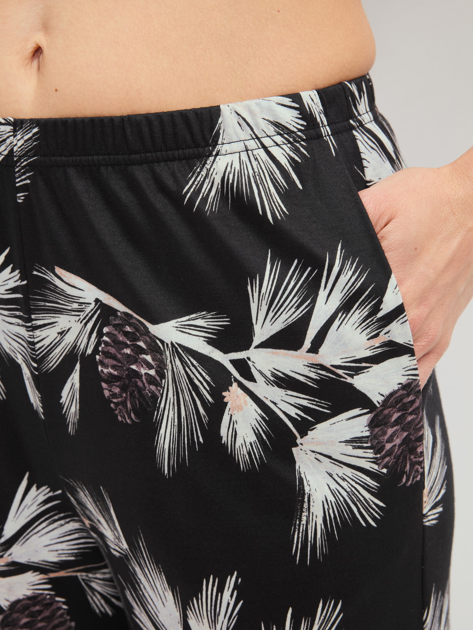 Damen-Model trägt Pyjamahose mit Seitentaschen aus Modal in Schwarz, Floral aus Serie Glimmer M&M von CALIDA, Detail