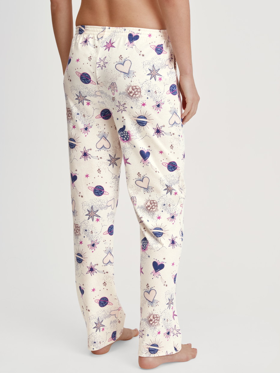 Damen-Model trägt Pyjamahose mit Seitentaschen aus 100% Baumwolle in Beige, Gemustert aus Serie Favourites Universe von CALIDA, Rückansicht