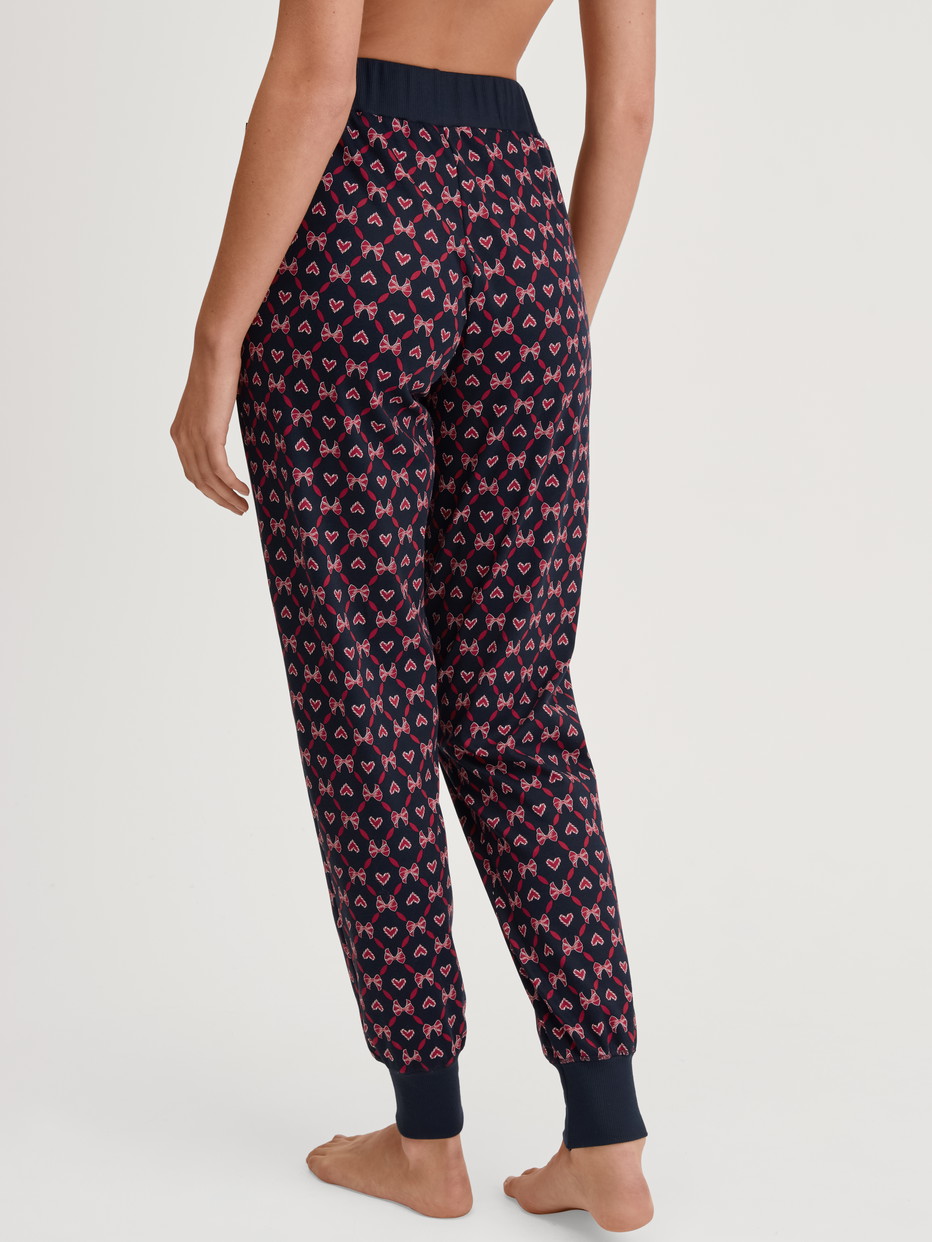 Damen-Model trägt Pyjamahose mit Bündchen und Seitentaschen aus 100% Baumwolle in Blau, Gemustert aus Serie Favourites Holidays von CALIDA, Rückansicht