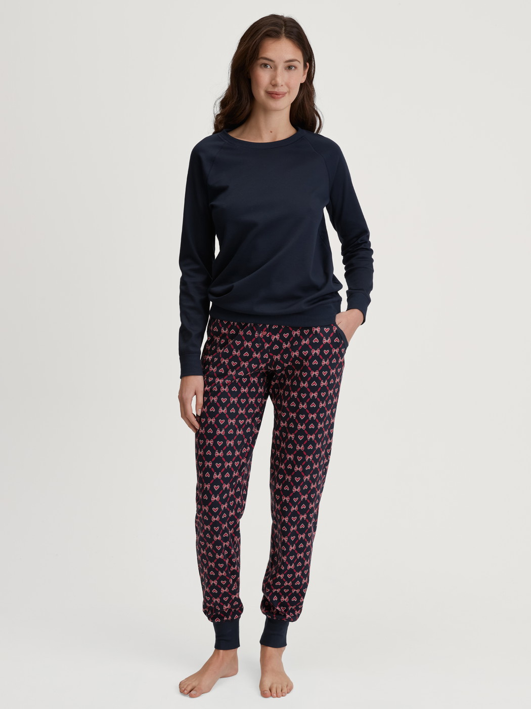 Damen-Model trägt Pyjamahose mit Bündchen und Seitentaschen aus 100% Baumwolle in Blau, Gemustert aus Serie Favourites Holidays von CALIDA, Outfit
