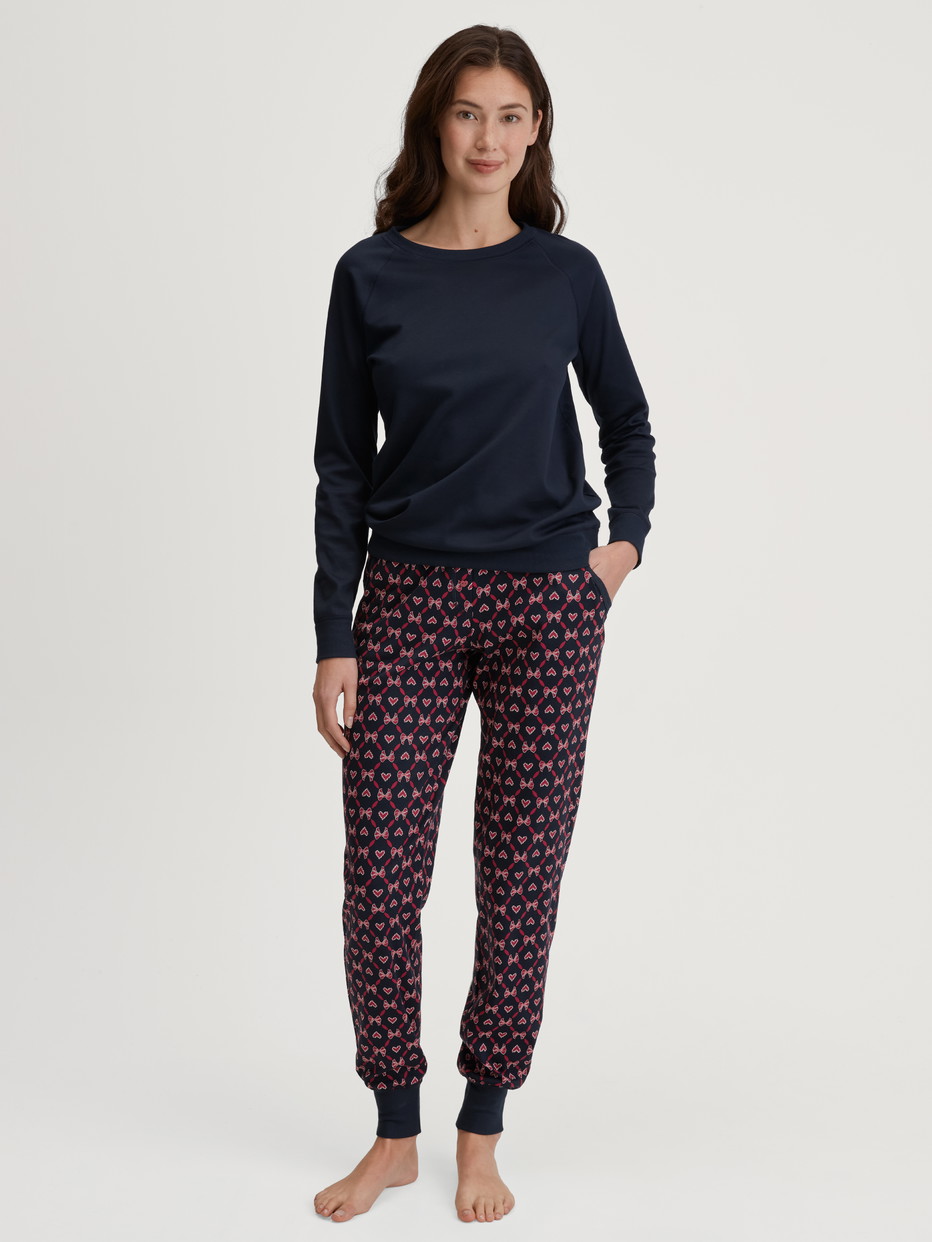 Damen-Model trägt Pyjamahose mit Bündchen und Seitentaschen aus 100% Baumwolle in Blau, Gemustert aus Serie Favourites Holidays von CALIDA, Outfit