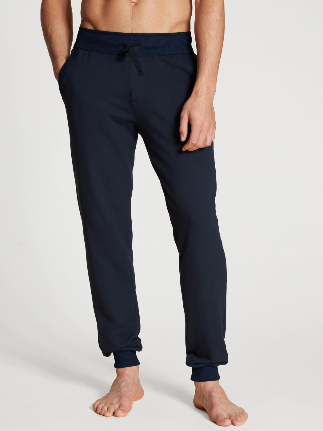 La modella / Il modello Uomo indossa Pantaloni da ginnastica, compostabili in 100% cotone di colore Blu, Tinta unita, della serie Circular Lounge di CALIDA, Vista frontale