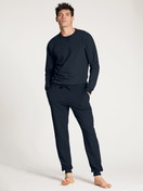 La modella / Il modello Uomo indossa Pantaloni da ginnastica, compostabili in 100% cotone di colore Blu, Tinta unita, della serie Circular Lounge di CALIDA, Vista frontale, Abbigliamento