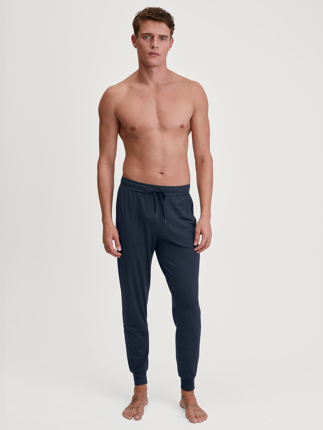 La modella / Il modello Uomo indossa Pantaloni pigiama con polsini in Modal di colore Blu, Tinta unita, della serie DSW Balancing di CALIDA, Abbigliamento
