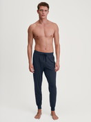 La modella / Il modello Uomo indossa Pantaloni pigiama con polsini in Modal di colore Blu, Tinta unita, della serie DSW Balancing di CALIDA, Abbigliamento