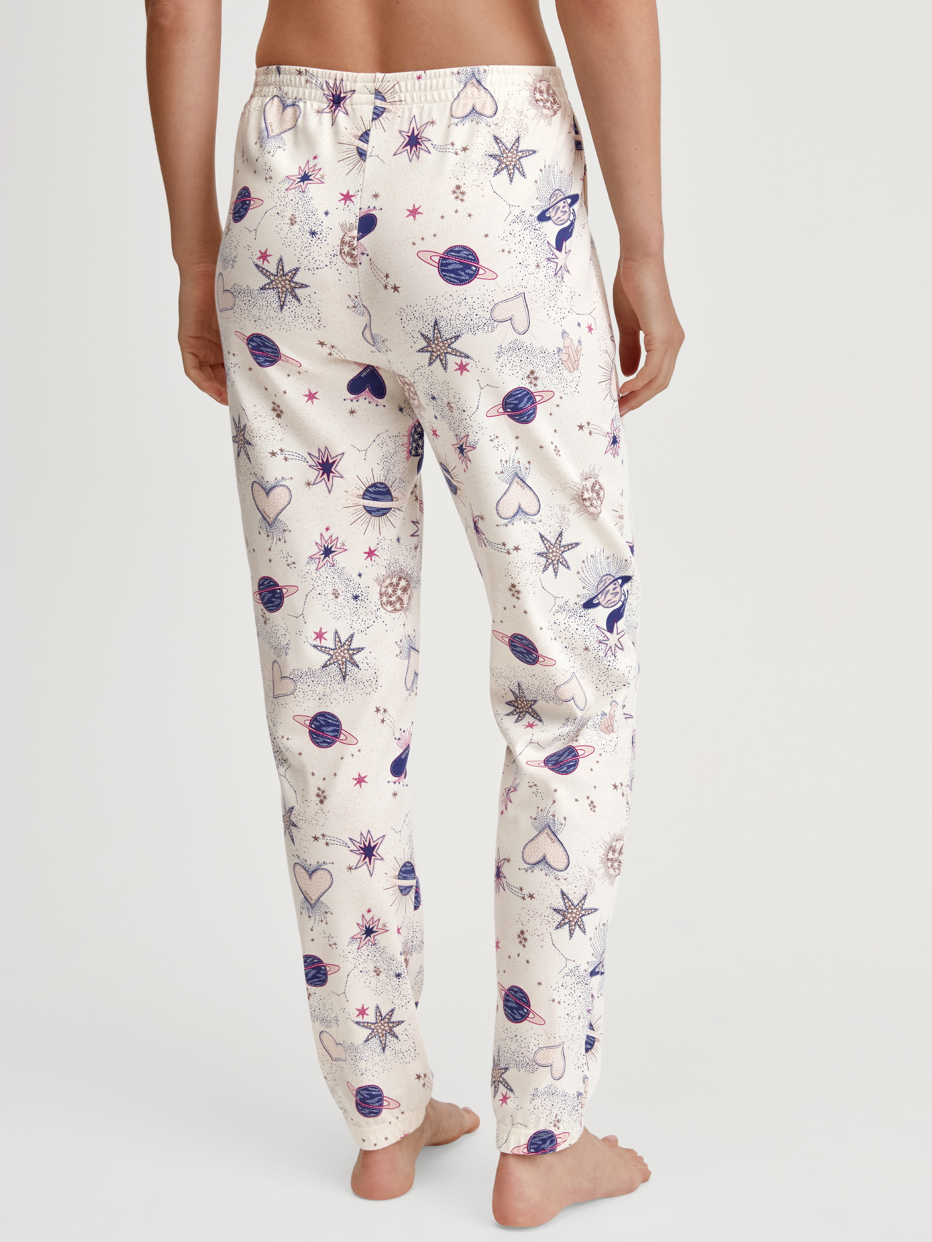 Women model is wearing Pyjama bottom with cuffs made of 100% Cotton in Beige, Patterned from the Favourites Universe series by CALIDA, Back view