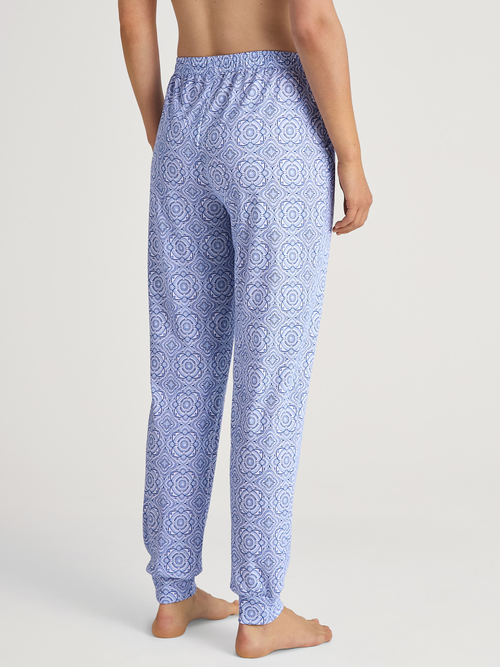 Damen-Model trägt Pyjamahose mit Bündchen aus Baumwolle in Blau, Gemustert aus Serie Favourites Marine von CALIDA, Rückansicht