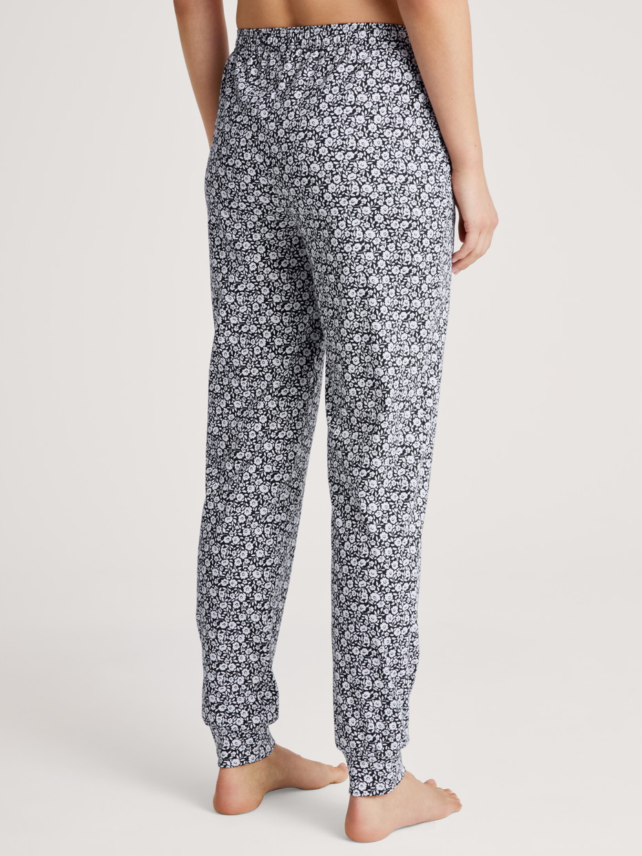 Damen-Model trägt Pyjamahose mit Bündchen aus 100% Baumwolle in Blau, Floral aus Serie Favourites Joy II von CALIDA, Rückansicht