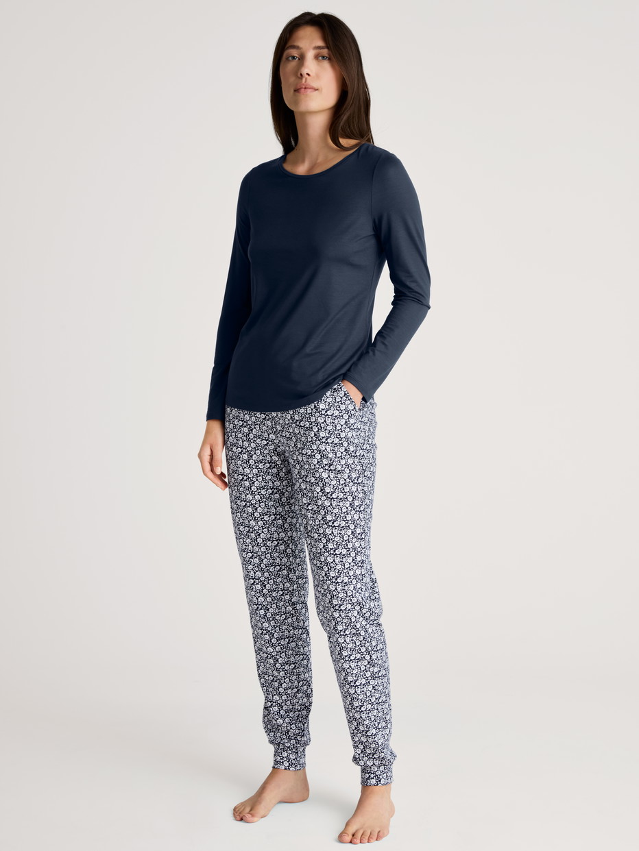 Damen-Model trägt Pyjamahose mit Bündchen aus 100% Baumwolle in Blau, Floral aus Serie Favourites Joy II von CALIDA, Outfit
