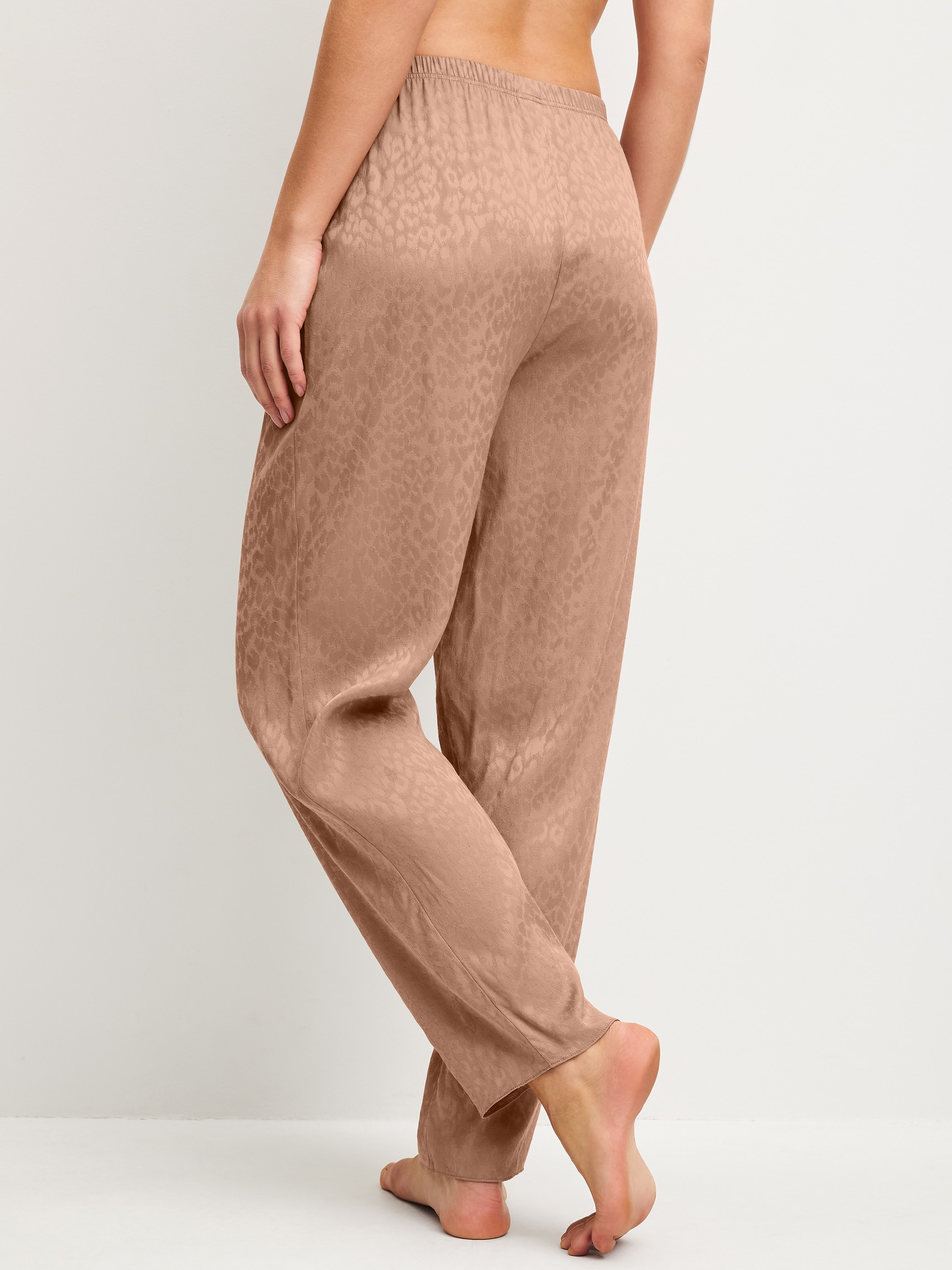 Women model is wearing Pyjama trousers with side pockets made of Viscose in Brown, Patterned from the Glimmer M&M series by CALIDA, Back view
