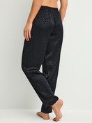 Damen-Model trägt Pyjamahose mit Seitentaschen aus Viskose in Schwarz, Gemustert aus Serie Glimmer M&M von CALIDA, Rückansicht