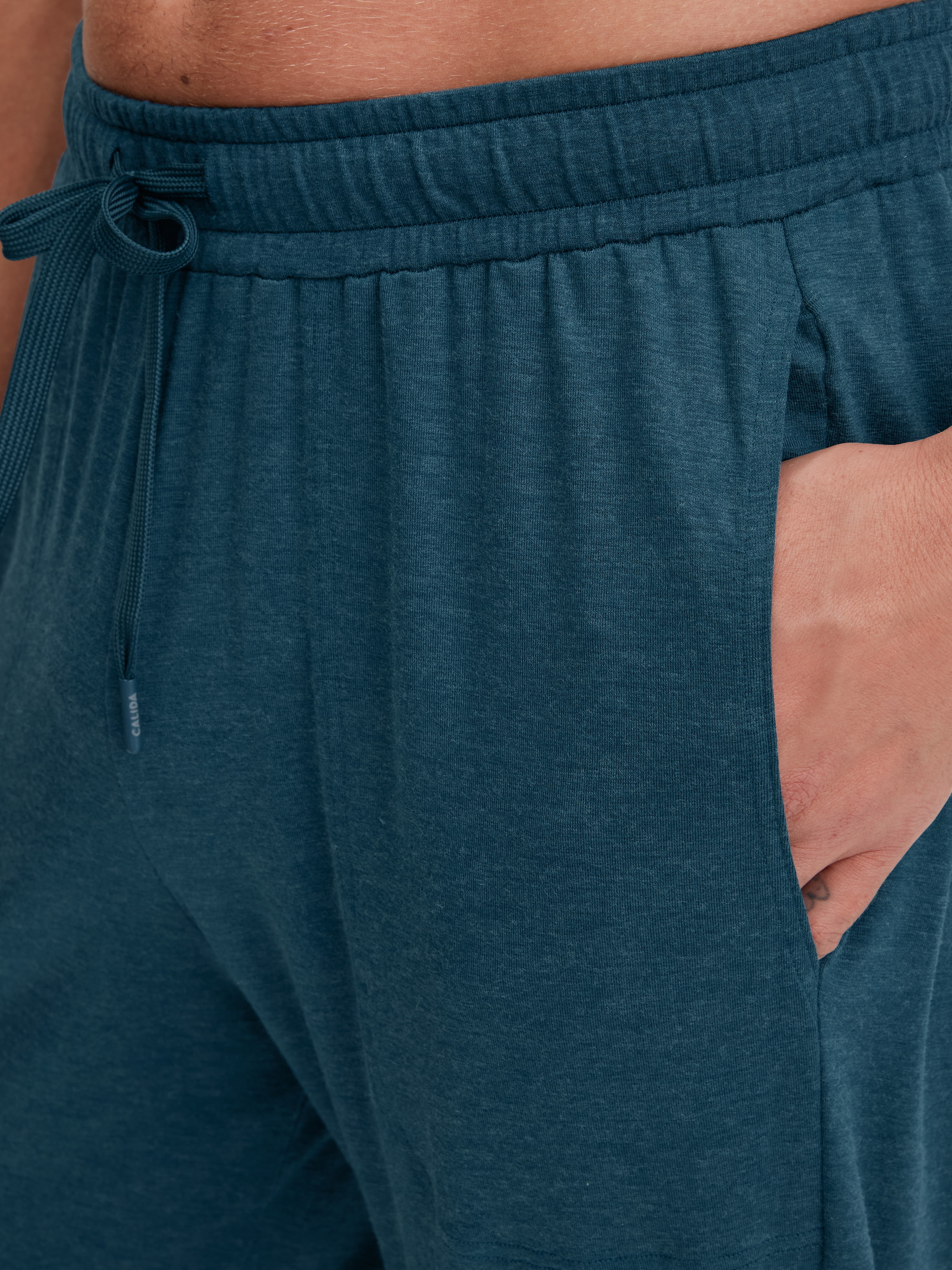 Men model is wearing Pyjama bottom with cuffs made of TENCEL™ in Turquoise, Unicoloured from the DSW Warming series by CALIDA, Detail