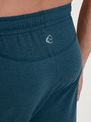 La modella / Il modello Uomo indossa Pantaloni pigiama con polsini in TENCEL™ di colore Turchese, Tinta unita, della serie DSW Warming di CALIDA, Dettaglio