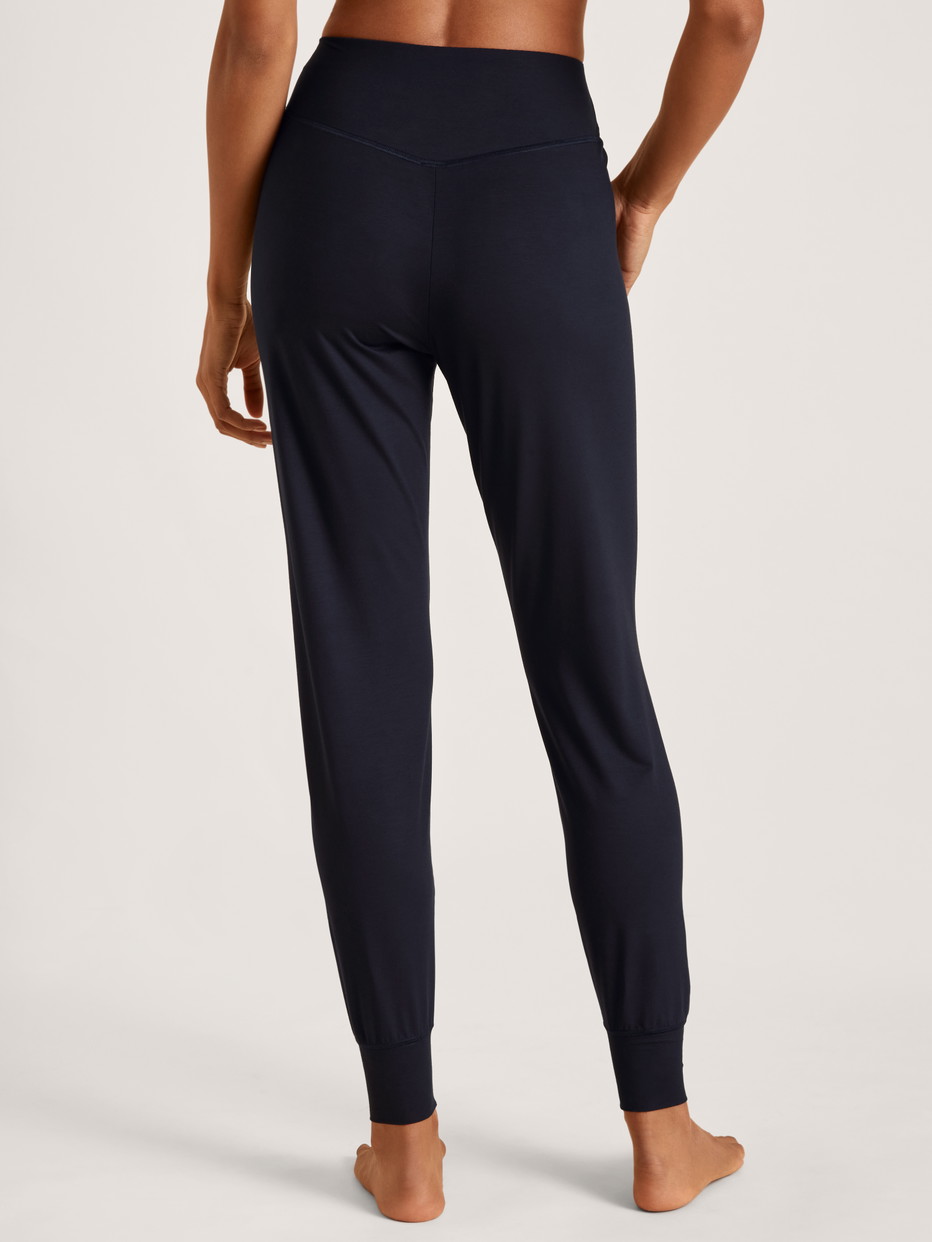 La modella / Il modello Donna indossa Pantaloni pigiama con polsini in Modal di colore Blu, Tinta unita, della serie DSW Balancing di CALIDA, Vista posteriore