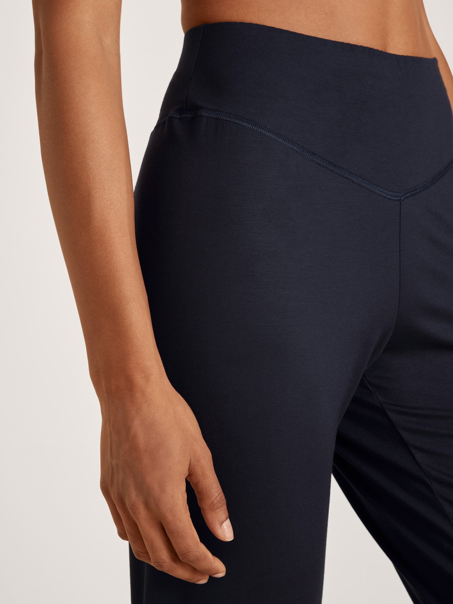 La modella / Il modello Donna indossa Pantaloni pigiama con polsini in Modal di colore Blu, Tinta unita, della serie DSW Balancing di CALIDA, Dettaglio