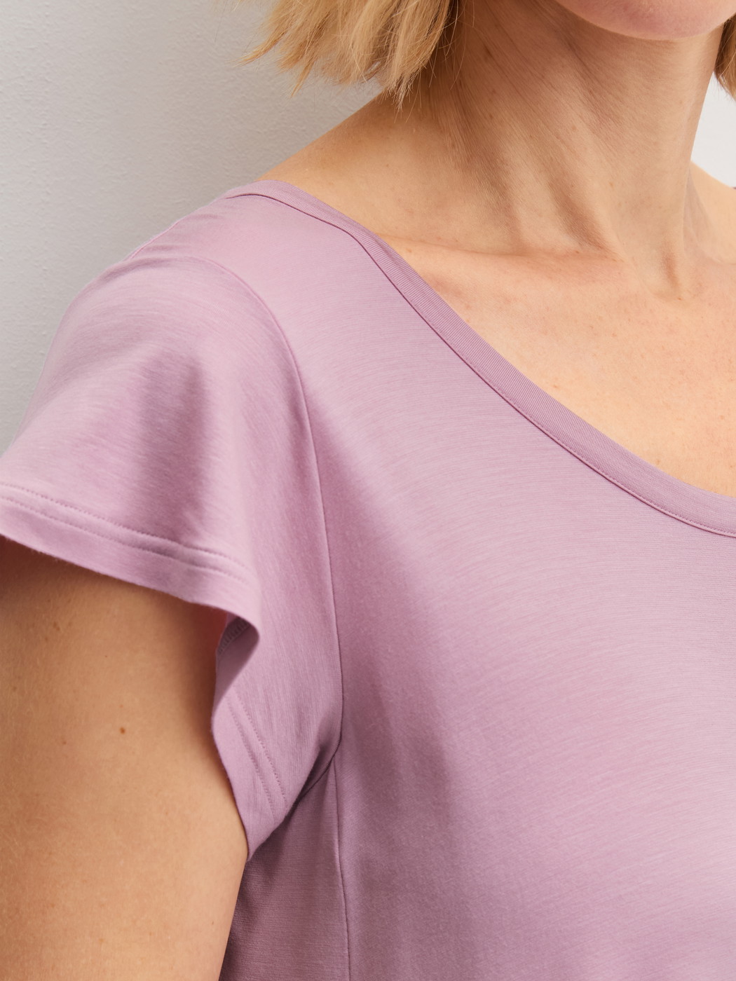 La modella / Il modello Donna indossa Camicia da notte a maniche corte, lunghezza 90 cm in Modal di colore Viola, Tinta unita, della serie DSW Balancing di CALIDA, Dettaglio