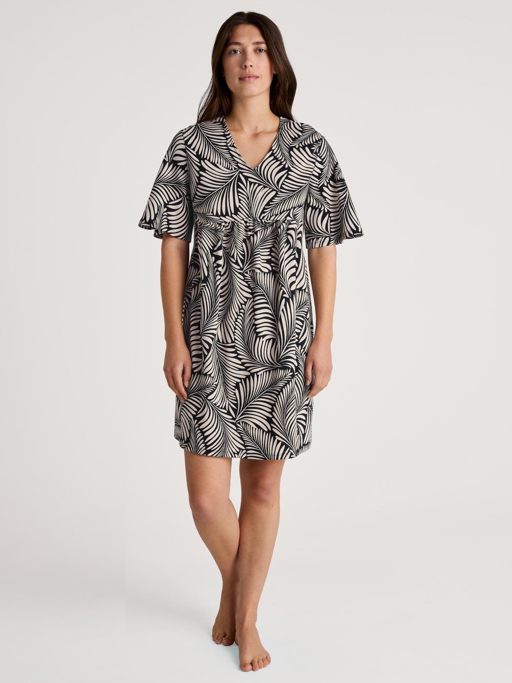 Damen-Model trägt Kurzarm-Nachthemd, Länge 95 cm aus 100% Baumwolle in Schwarz, Floral aus Serie Favourites Sun von CALIDA, Vorderansicht