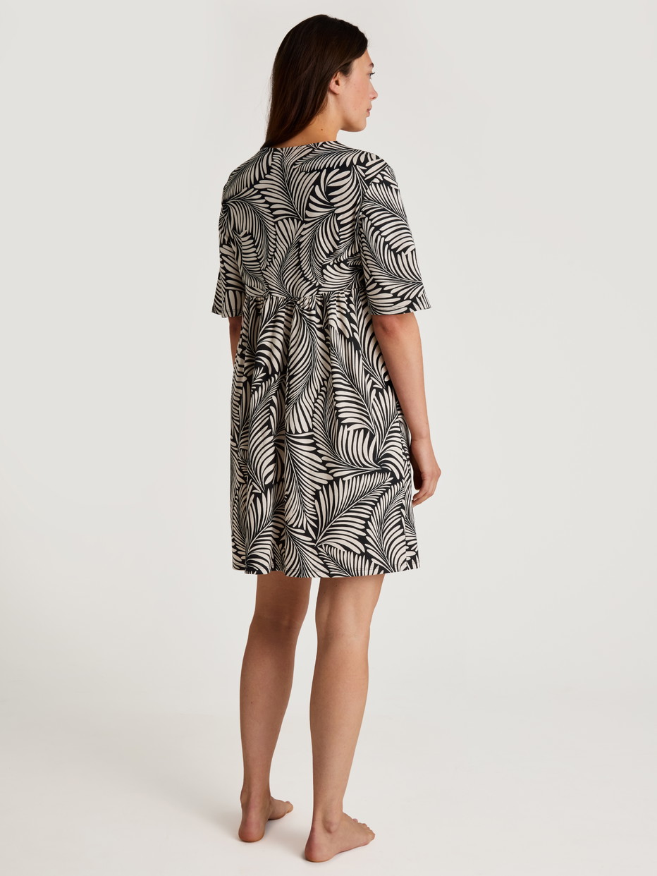 Damen-Model trägt Kurzarm-Nachthemd, Länge 95 cm aus 100% Baumwolle in Schwarz, Floral aus Serie Favourites Sun von CALIDA, Rückansicht