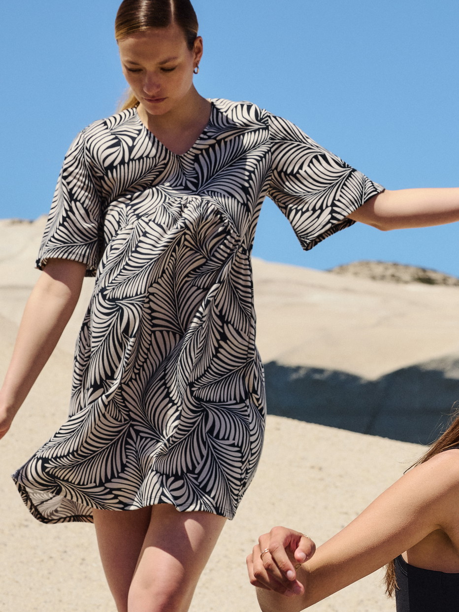 Damen-Model trägt Kurzarm-Nachthemd, Länge 95 cm aus 100% Baumwolle in Schwarz, Floral aus Serie Favourites Sun von CALIDA, Vorderansicht