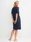 Women model is wearing Short-sleeved nightdress, length 100 cm made of Cotton in Blue, Unicoloured from the Favourites Tiles series by CALIDA, Back view
