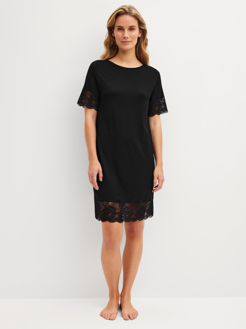 Damen-Model trägt Kurzarm-Nachthemd, Länge 95 cm aus Modal in Schwarz, Spitze aus Serie Elegant Dreams von CALIDA, Vorderansicht