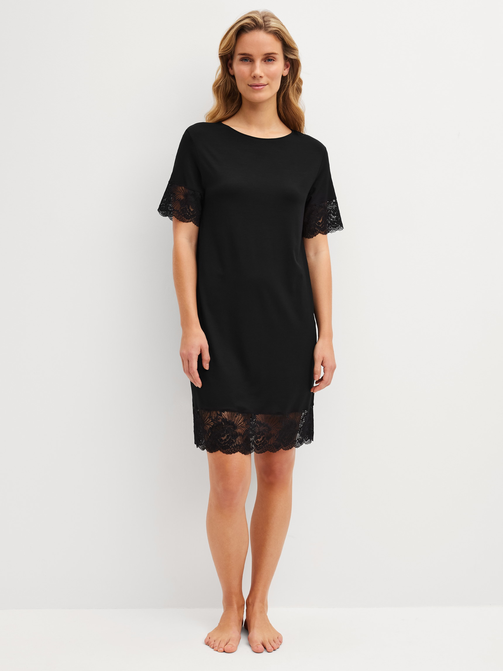 La modella / Il modello Donna indossa Camicia da notte a maniche corte, lunghezza 95 cm in Modal di colore Nero, Pizzo, della serie Elegant Dreams di CALIDA, Vista frontale