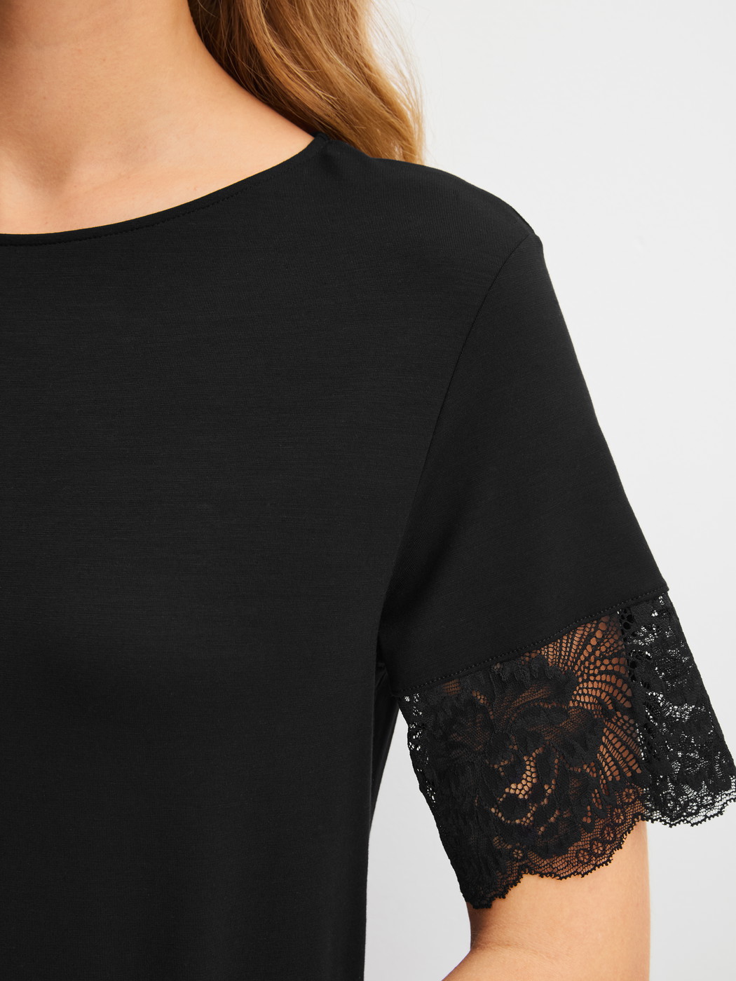 Damen-Model trägt Kurzarm-Nachthemd, Länge 95 cm aus Modal in Schwarz, Spitze aus Serie Elegant Dreams von CALIDA, Detail